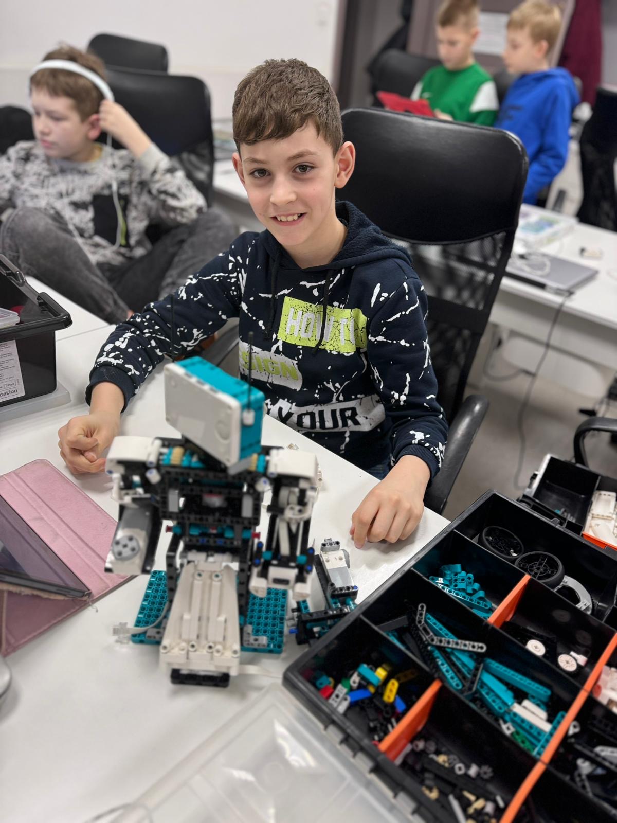 Chłopiec prezentujący budowlę z LEGO